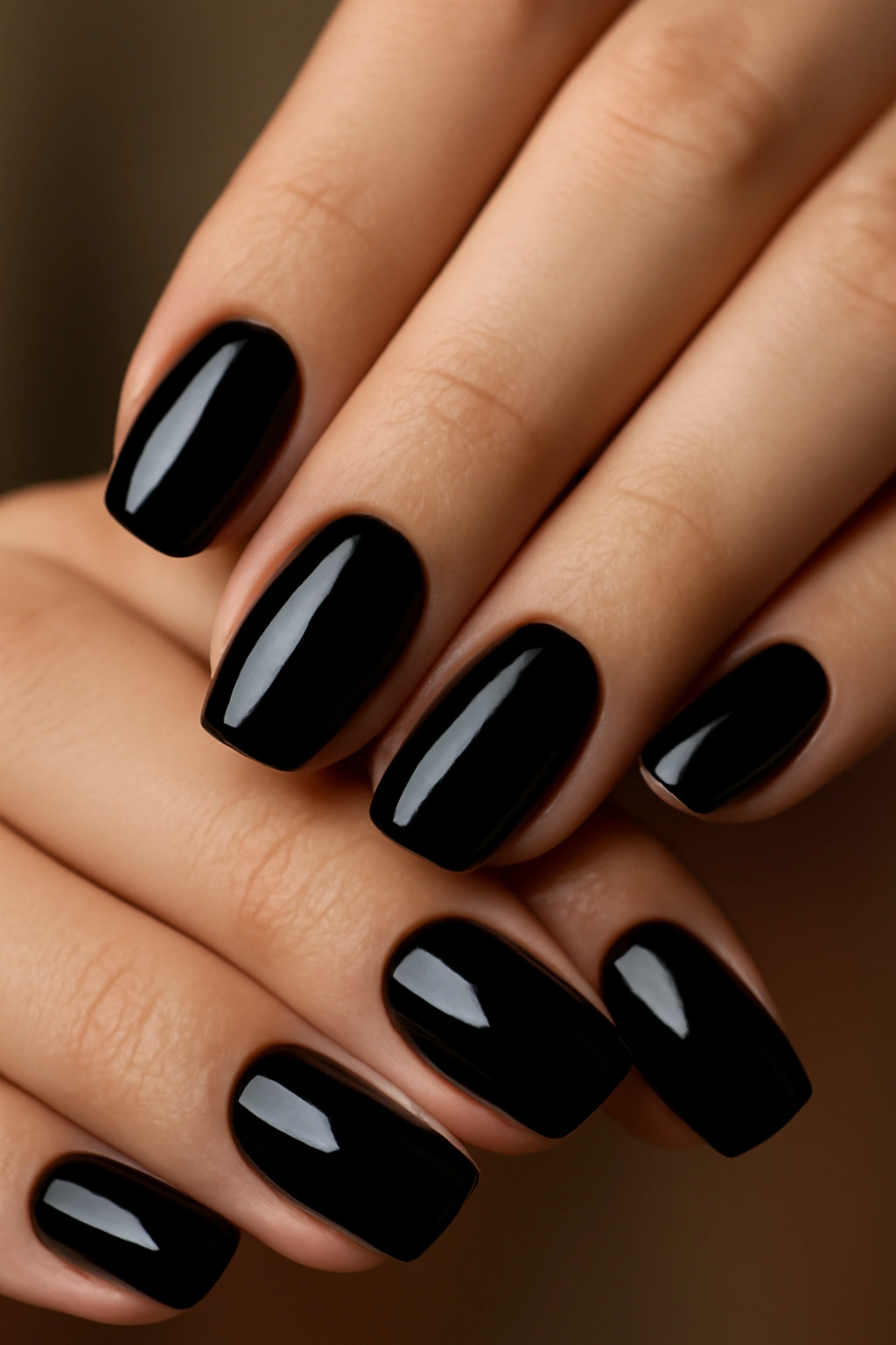 Close-up of glossy black nails with mirror-like finish on fingertips
