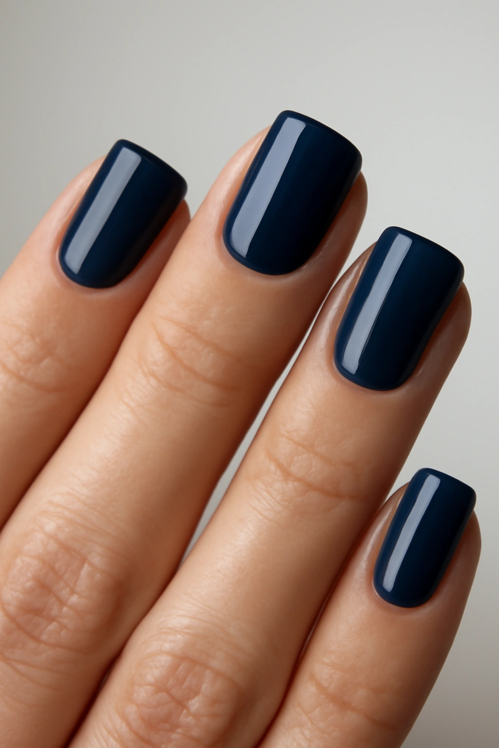 Close-up of navy blue nails on a hand.