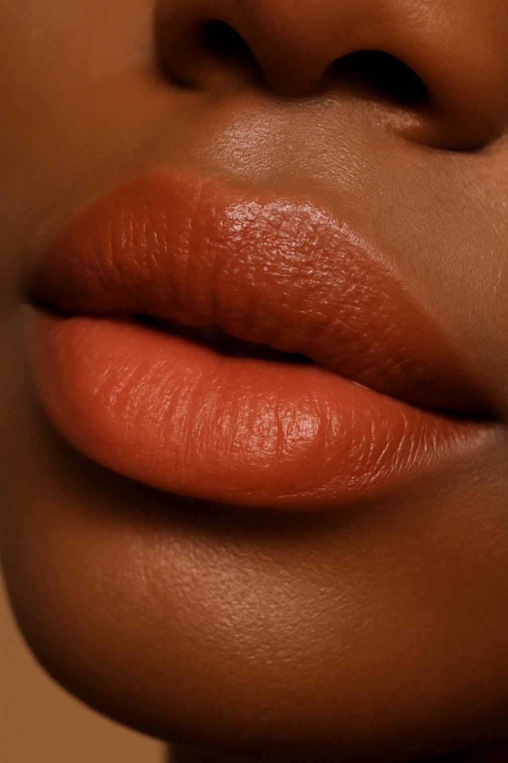 Close-up of lips in warm peach lipstick with soft glow